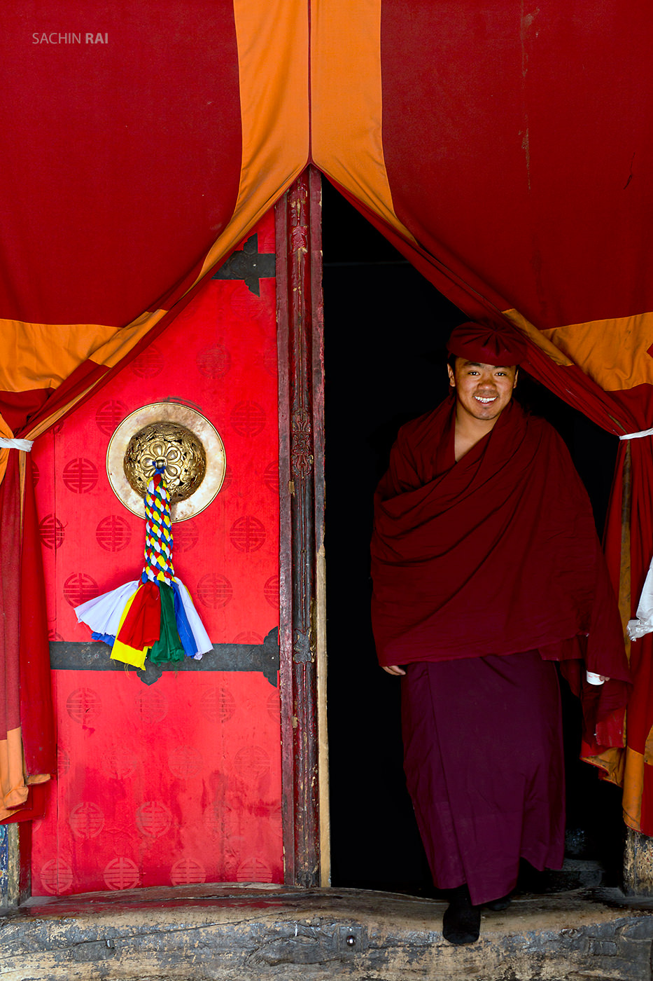 A monk stepping out of a monastery in Ladakh, India.